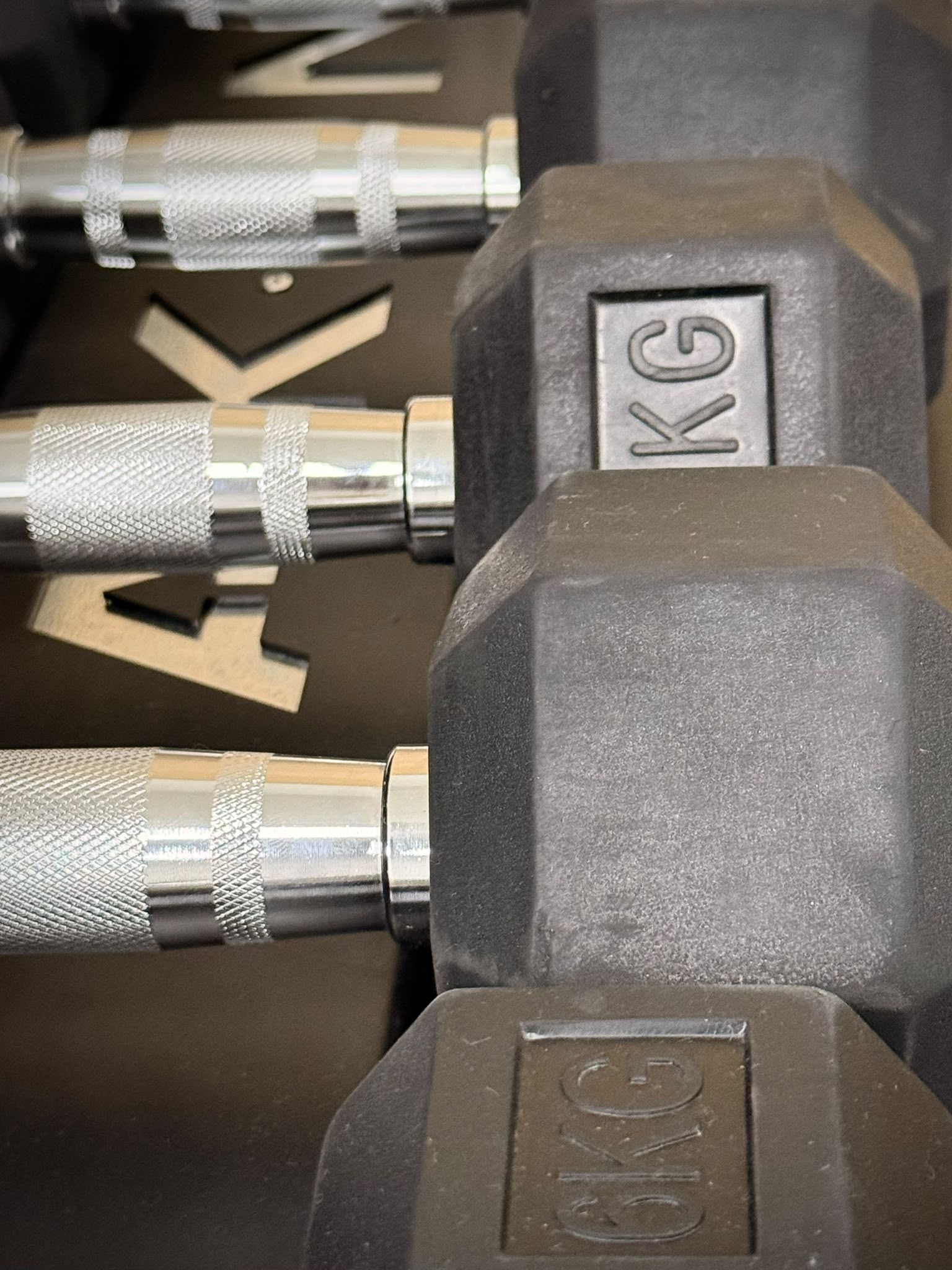 Mancuernas ordenadas sobre soporte metalico.