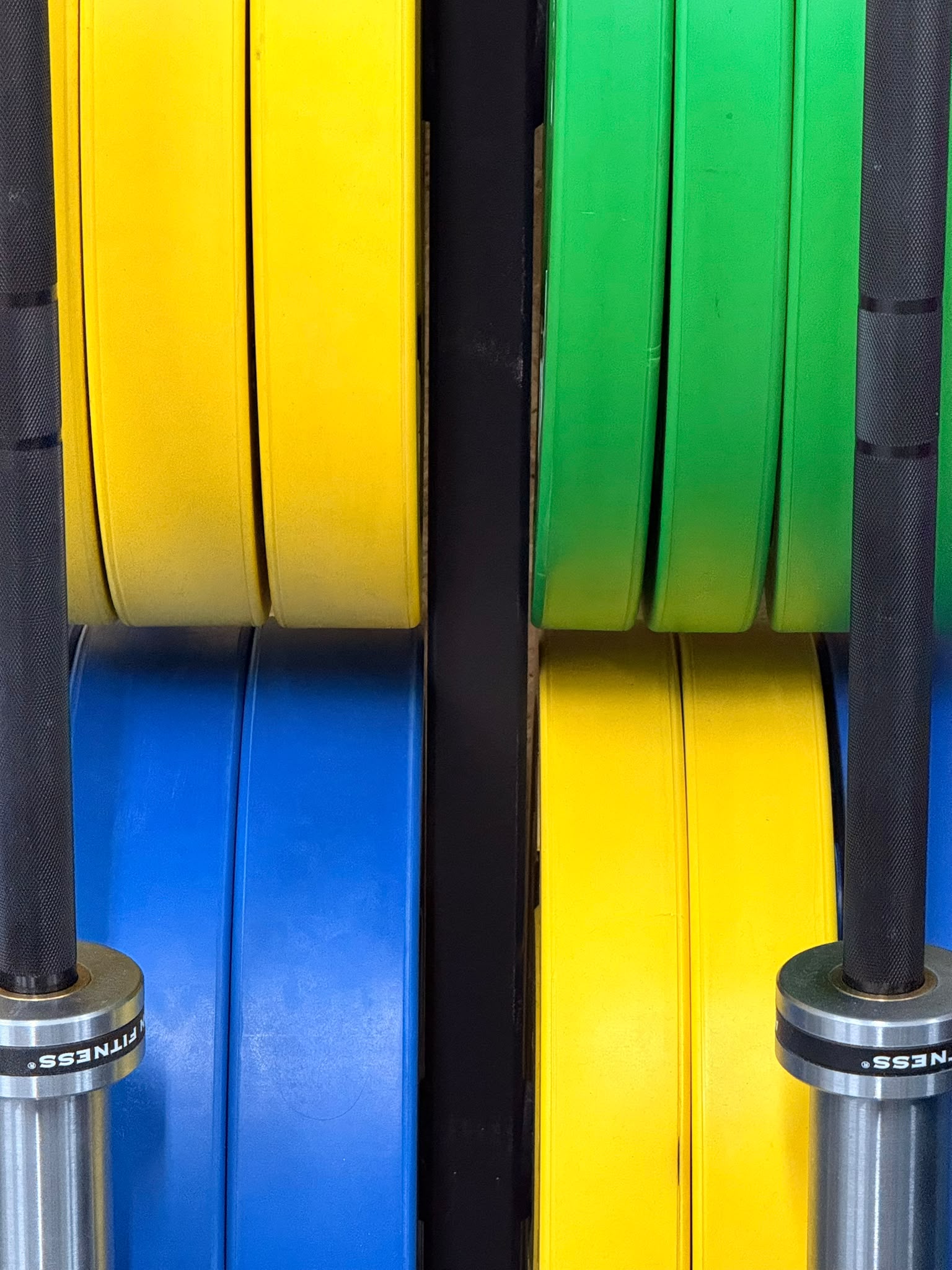 Detalle editorial de discos de colores y barras de entrenamiento.