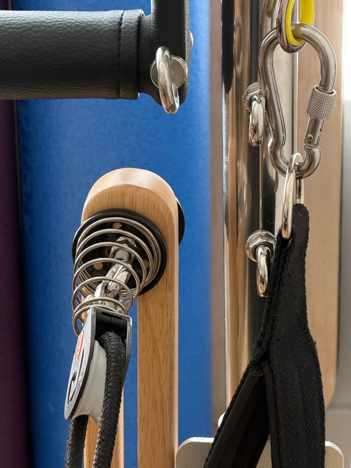Detalle de correas, mosquetones y muelles de un equipo de Pilates.