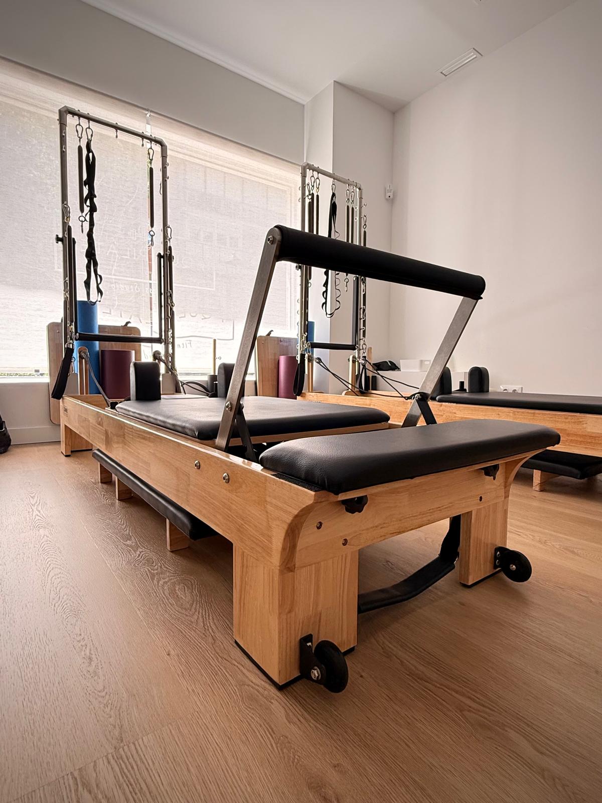 Estudio de Pilates con reformers de madera y luz natural.