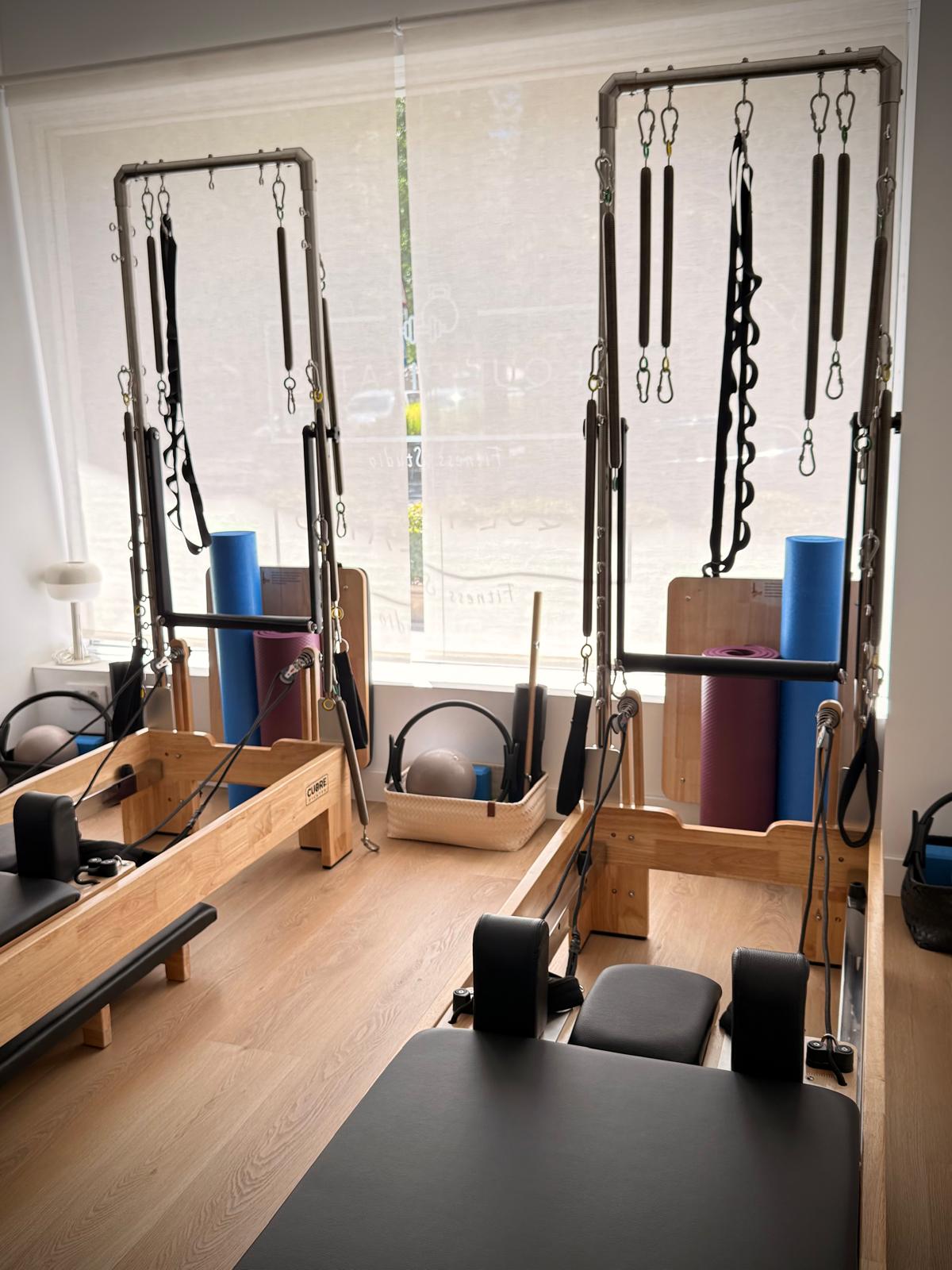 Vista general de la sala de Pilates con reformers, torre y accesorios.